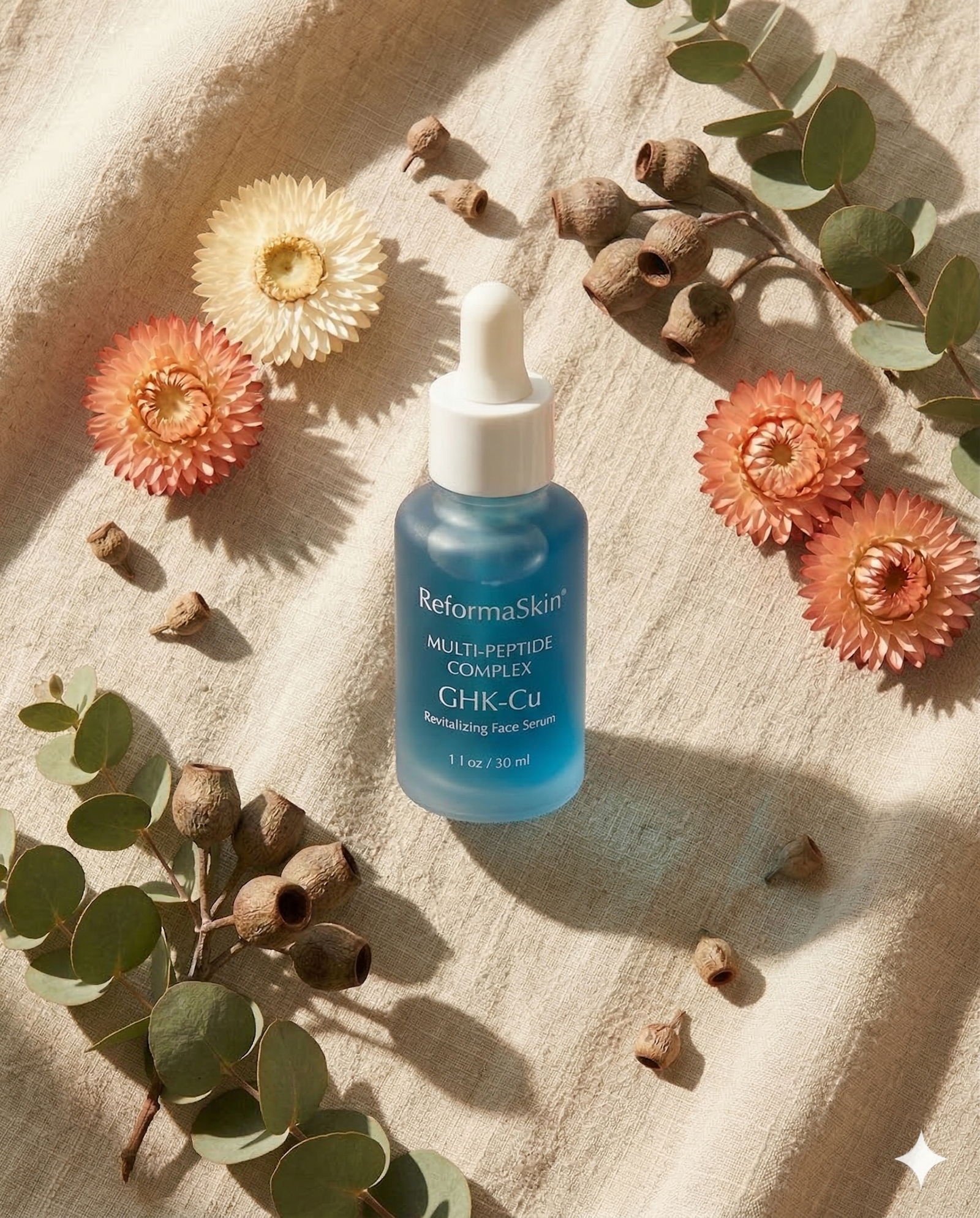 Serum bottle on mirror with dried botanicals